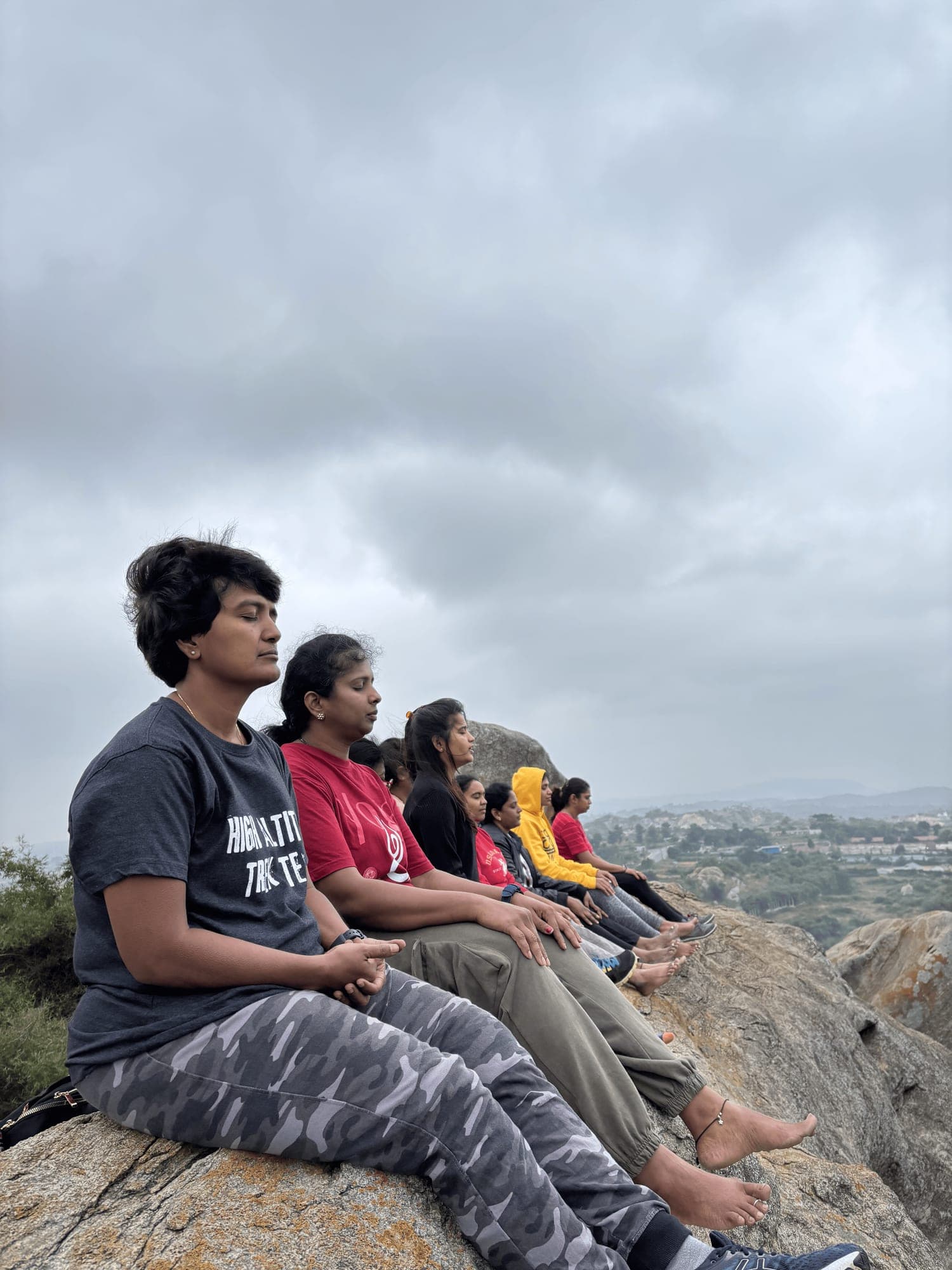 YogaNiroga group meditating on a rock during a trek